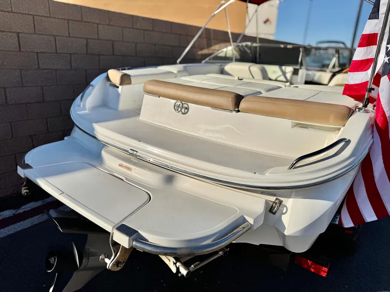 Slide: The Image of 2017 Cobalt 220S boat with American flag, rear view, beige seating. - 8
