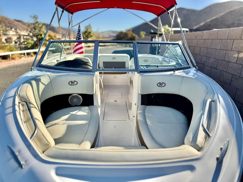 Slide: The Image of 2017 Cobalt 220S boat with red canopy and American flag, docked near mountains. - 9