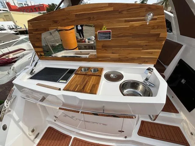 Slide: The Image of 2023 NX Boats 360 yacht kitchen with wooden countertop and modern amenities. - 10