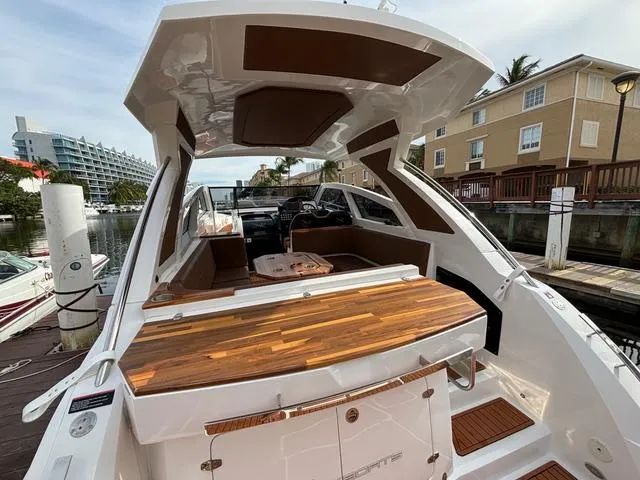 Slide: The Image of 2023 NX Boats 360 with sleek design and wooden deck, docked at a marina. - 11