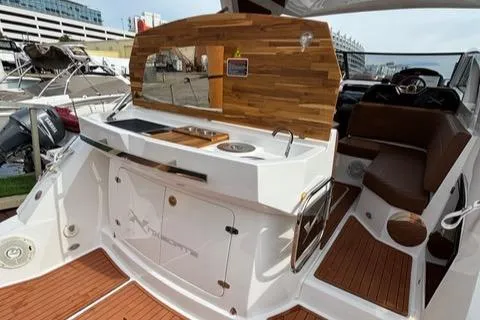 Slide: The Image of 2023 NX Boats 360 interior with kitchenette and seating area. - 12
