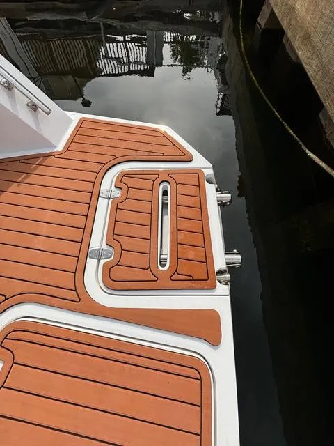 Slide: The Image of 2023 NX Boats 360 swim platform with teak decking by the water. - 16