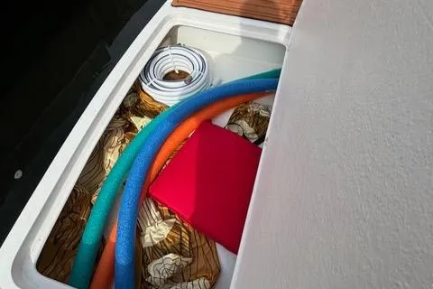 Slide: The Image of Storage compartment on 2023 NX Boats 360 with pool noodles and accessories. - 17
