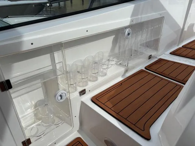 Slide: The Image of 2023 NX Boats 360 interior with glass storage and wooden flooring. - 18