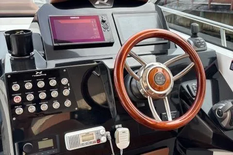 Slide: The Image of 2023 NX Boats 360 dashboard with wooden steering wheel and modern controls. - 19