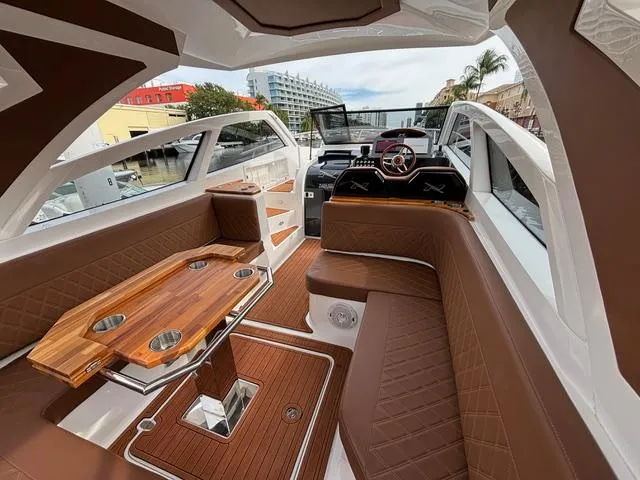 Slide: The Image of Luxurious 2023 NX Boats 360 interior with elegant seating and wooden table. - 23