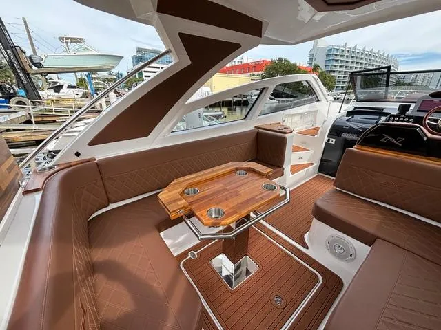 Slide: The Image of Luxurious interior of 2023 NX Boats 360 with brown leather seating and wooden table. - 24