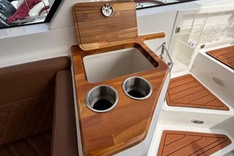Slide: The Image of 2023 NX Boats 360 interior with wooden finish and dual cup holders. - 26
