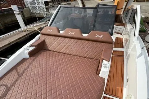 Slide: The Image of 2023 NX Boats 360 with luxurious brown quilted seating and sleek design. - 27