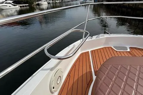 Slide: The Image of 2023 NX Boats 360 with teak deck and cushioned seating by the water. - 30