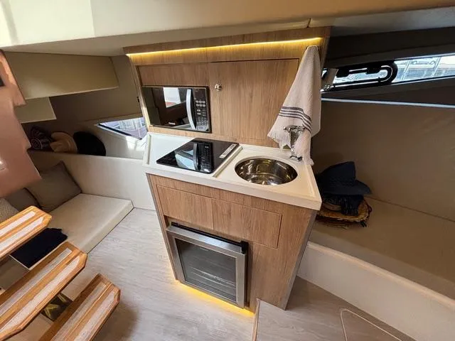 Slide: The Image of Modern kitchen area in 2023 NX Boats 360 yacht with wood cabinetry and compact appliances. - 33