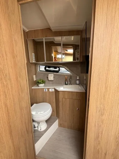 Slide: The Image of 2023 NX Boats 360 bathroom interior with wood finish and modern amenities. - 36