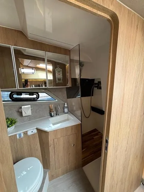 Slide: The Image of Modern bathroom interior of 2023 NX Boats 360 with wood accents and sleek fixtures. - 37