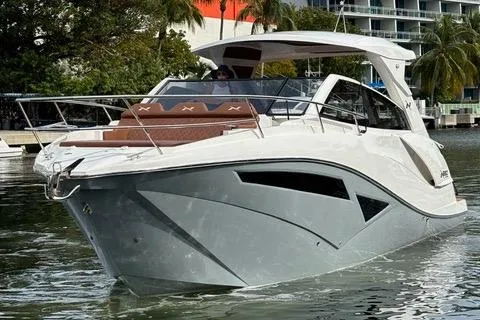Slide: The Image of 2023 NX Boats 360 cruising on water, modern design, palm trees in background. - 6