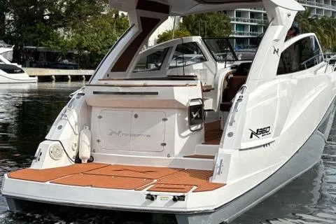 Slide: The Image of 2023 NX Boats 360 luxury yacht with sleek design, docked on calm water. - 8