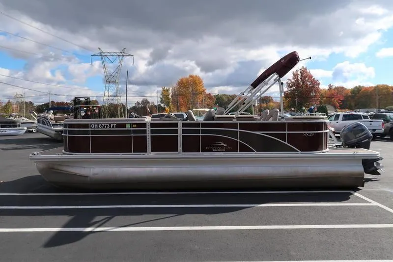 Slide: The Image of 2018 Bennington 23SPDXP pontoon boat in parking lot, autumn trees in background. - 7