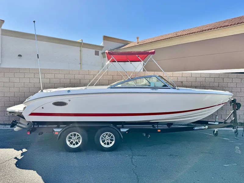 The Image of 2017 Cobalt 220S boat with red canopy on trailer, parked outdoors. - 0
