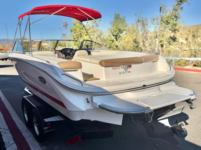 Slide: The Image of 2017 Cobalt 220S boat with red canopy on trailer, parked outdoors. - 4