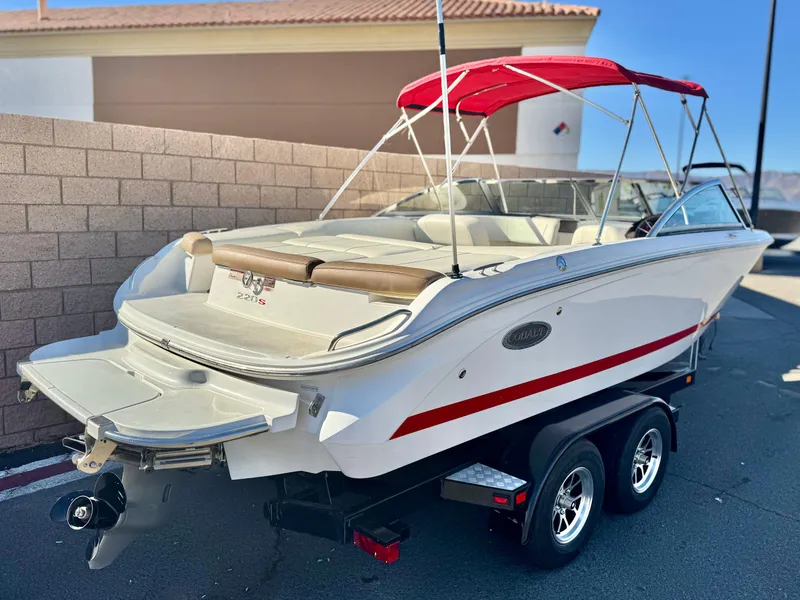 Slide: The Image of 2017 Cobalt 220S boat with red canopy on trailer, parked outdoors. - 6