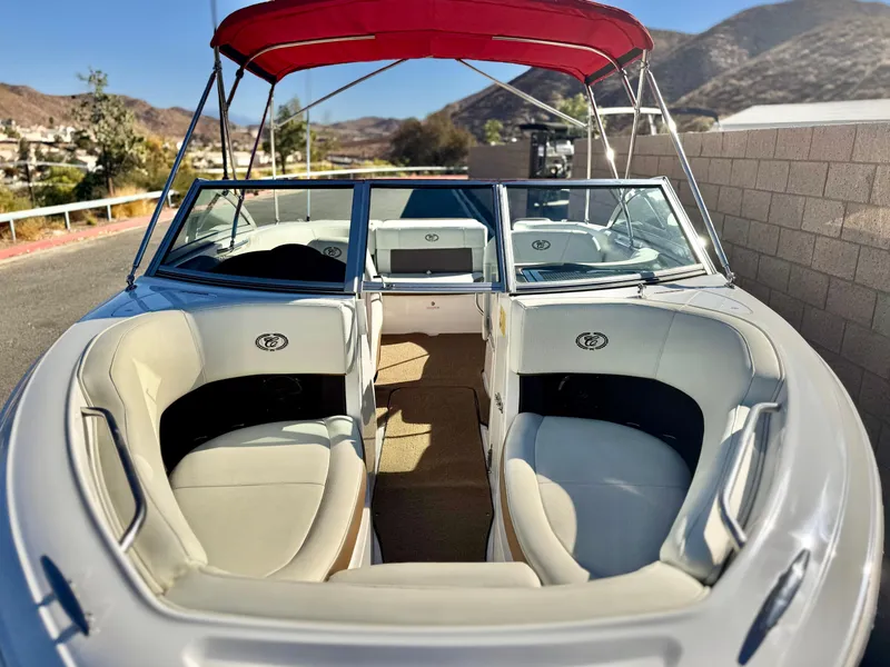 Slide: The Image of 2017 Cobalt 220S boat with red canopy, beige seating, and scenic mountain backdrop. - 9