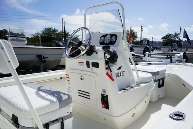 Slide: The Image of 2025 Mako 18 LTS boat interior with steering console and seating. - 11