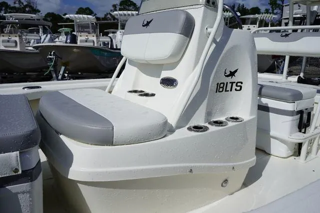 Slide: The Image of 2025 Mako 18 LTS boat with cushioned seating and rod holders. - 13