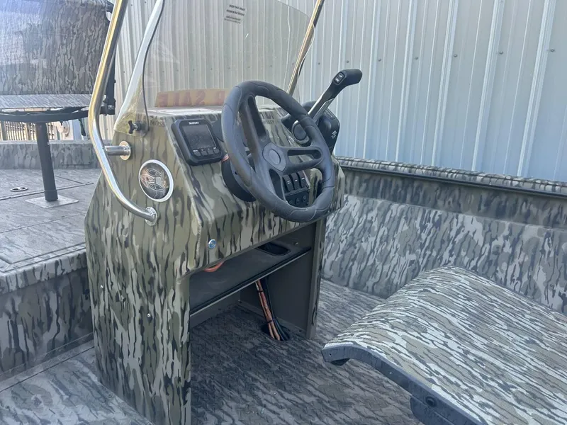 Slide: The Image of 2024 SeaArk Shadow 187 boat interior with camouflage design and steering console. - 2