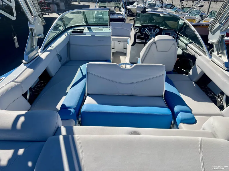 Slide: The Image of 2018 MasterCraft XT22 boat interior with blue and white seating, steering wheel, and dashboard. - 4