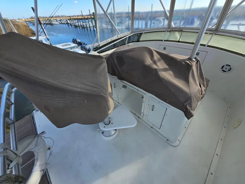 Slide: The Image of 1995 Egg Harbor 42 Convertible boat cockpit with covered seats, overlooking marina. - 12