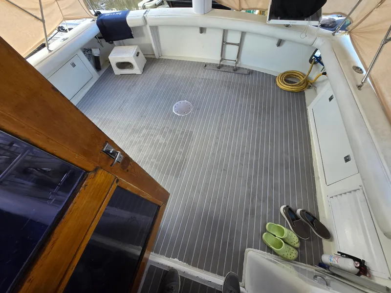 Slide: The Image of 1995 Egg Harbor 42 Convertible boat deck with seating, ladder, and shoes. - 16