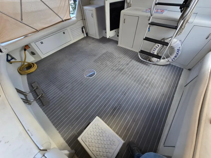 Slide: The Image of 1995 Egg Harbor 42 Convertible boat deck with storage, ladder, and marine equipment. - 18