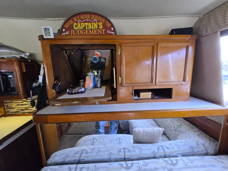 Slide: The Image of Interior of 1995 Egg Harbor 42 Convertible boat with wooden cabinetry and nautical-themed bedding. - 25