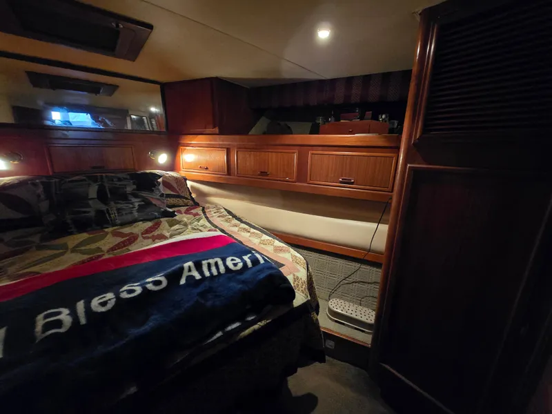 Slide: The Image of Cozy cabin interior of 1995 Egg Harbor 42 Convertible yacht with wooden cabinetry and bed. - 27