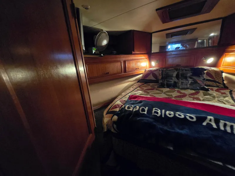Slide: The Image of Cozy cabin interior of 1995 Egg Harbor 42 Convertible with quilted bedding and warm lighting. - 28