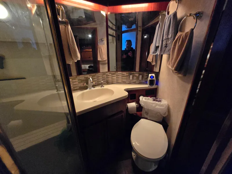Slide: The Image of Bathroom interior of 1995 Egg Harbor 42 Convertible yacht, featuring sink, toilet, and towels. - 33