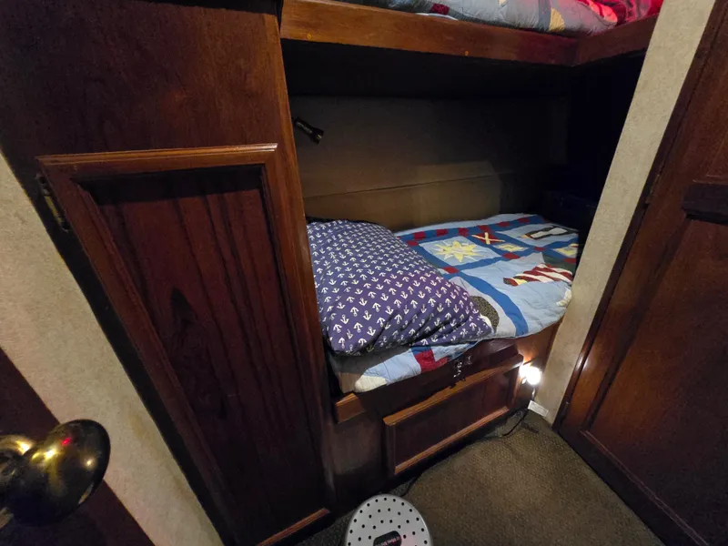 Slide: The Image of Bunk beds in 1995 Egg Harbor 42 Convertible yacht cabin, featuring cozy bedding and wooden finishes. - 34