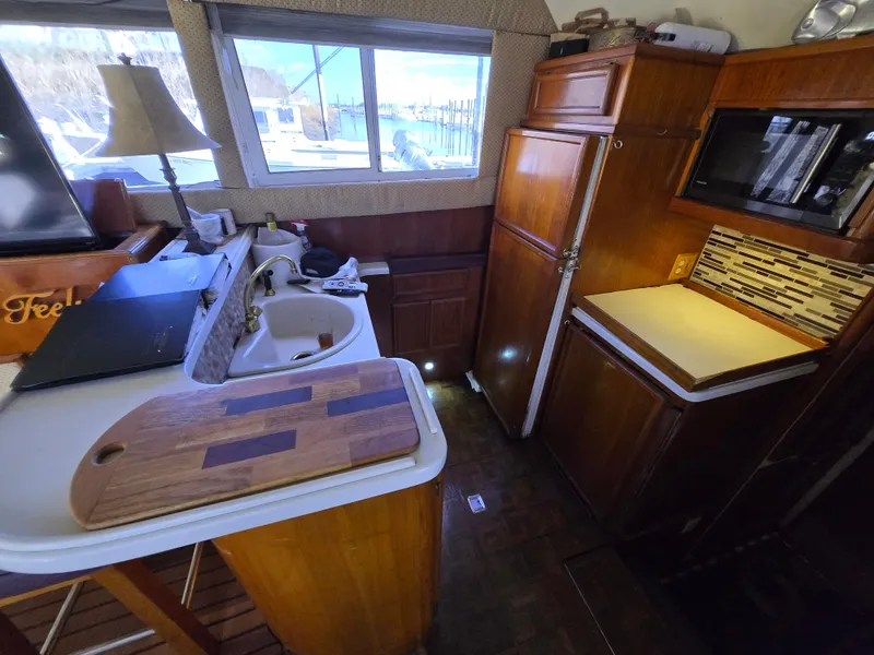 Slide: The Image of 1995 Egg Harbor 42 Convertible yacht kitchen with wooden cabinetry, sink, and cutting board. - 4