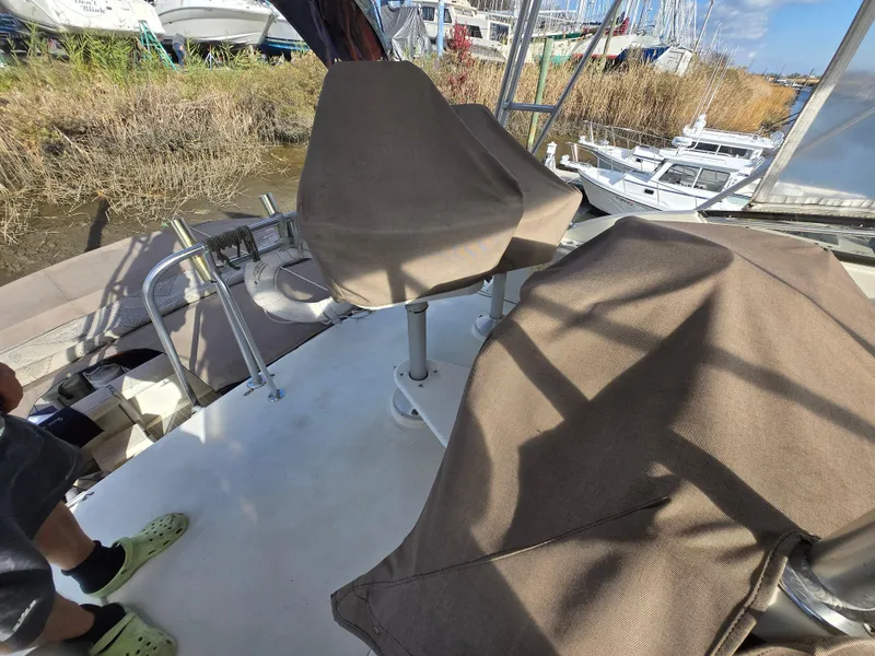 Slide: The Image of 1995 Egg Harbor 42 Convertible boat deck with covered seats and railing. - 46