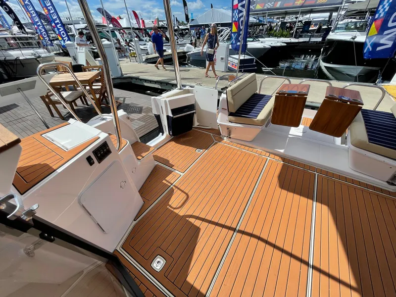 Slide: The Image of 2025 Ranger Tugs 43 Command Bridge with spacious teak deck at a boat show. - 11