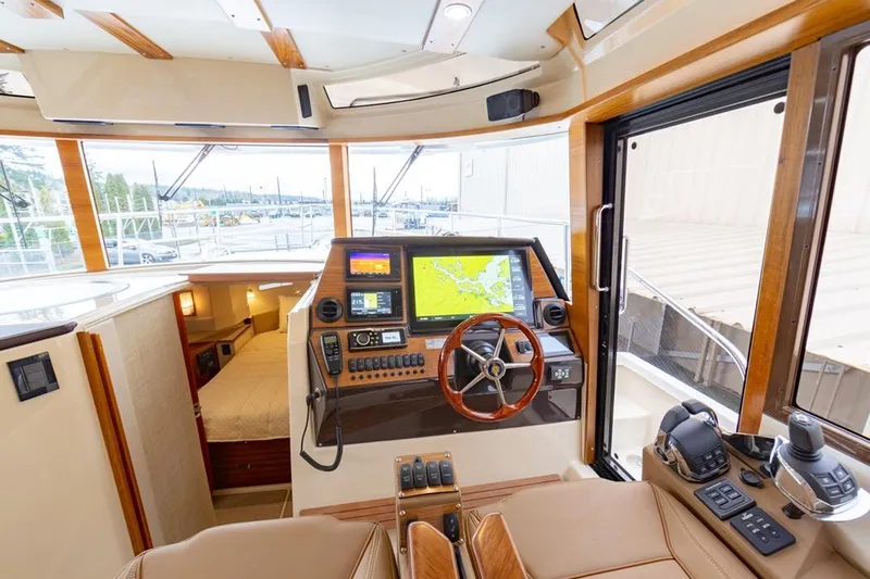Slide: The Image of 2025 Ranger Tugs 43 Command Bridge interior with navigation system and luxurious seating. - 24