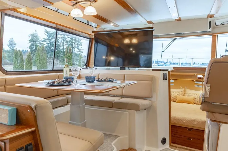 Slide: The Image of Luxurious interior of 2025 Ranger Tugs 43 Command Bridge with dining area and large windows. - 26