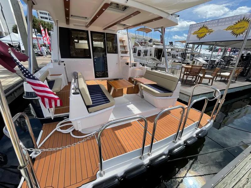 Slide: The Image of 2025 Ranger Tugs 43 Command Bridge with spacious deck and seating at marina. - 3