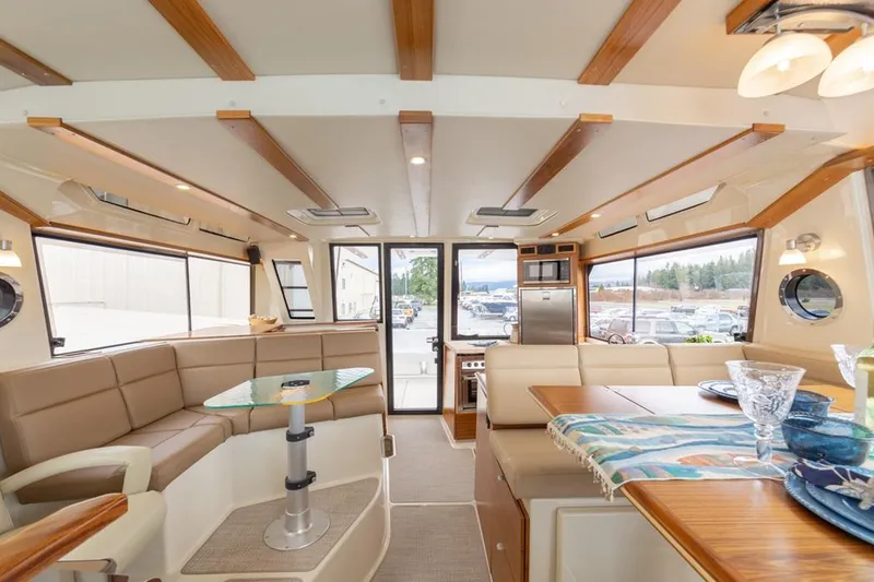 Slide: The Image of Luxurious interior of 2025 Ranger Tugs 43 Command Bridge yacht, featuring elegant seating and dining area. - 32