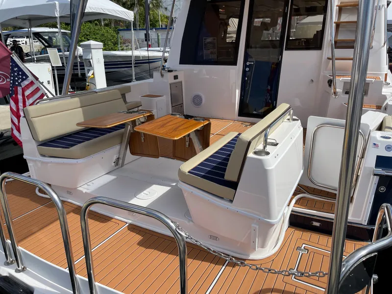 Slide: The Image of 2025 Ranger Tugs 43 Command Bridge with spacious outdoor seating and wooden deck. - 8
