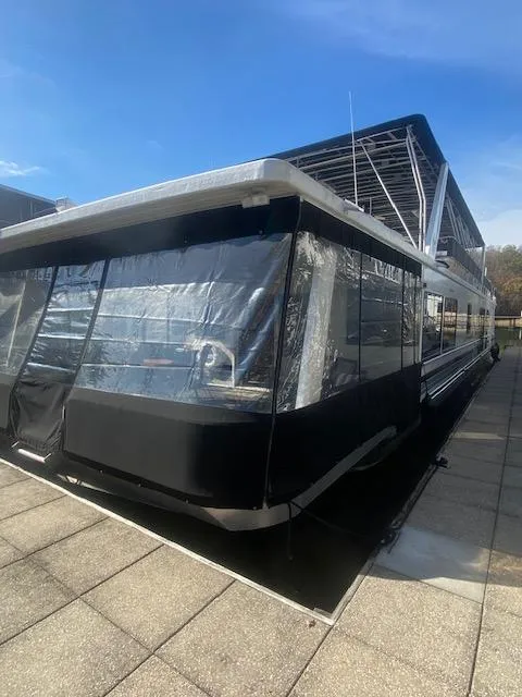 Slide: The Image of 2000 Sumerset 18x85 Houseboat with sleek design, docked under clear blue sky. - 0
