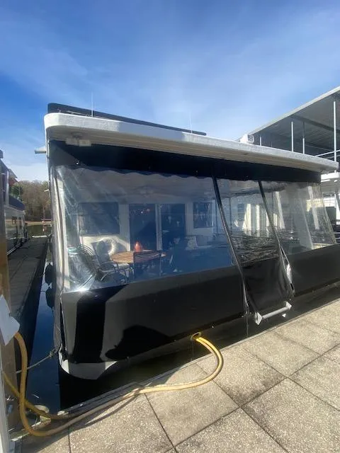 Slide: The Image of Sumerset 18x85 Houseboat 2000 with covered deck, docked under clear blue sky. - 1
