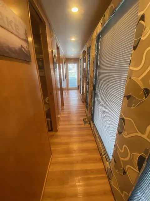 Slide: The Image of Interior hallway of 2000 Sumerset 18x85 houseboat with wooden flooring and patterned walls. - 10