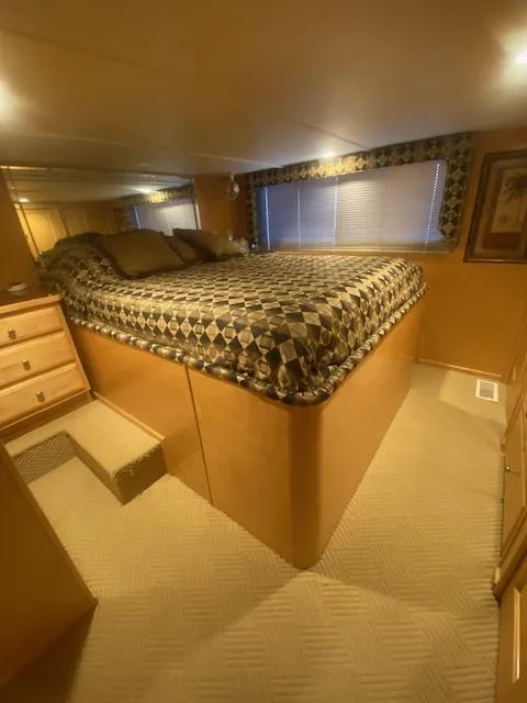 Slide: The Image of Cozy bedroom in 2000 Sumerset 18x85 houseboat with patterned bedding and warm lighting. - 14
