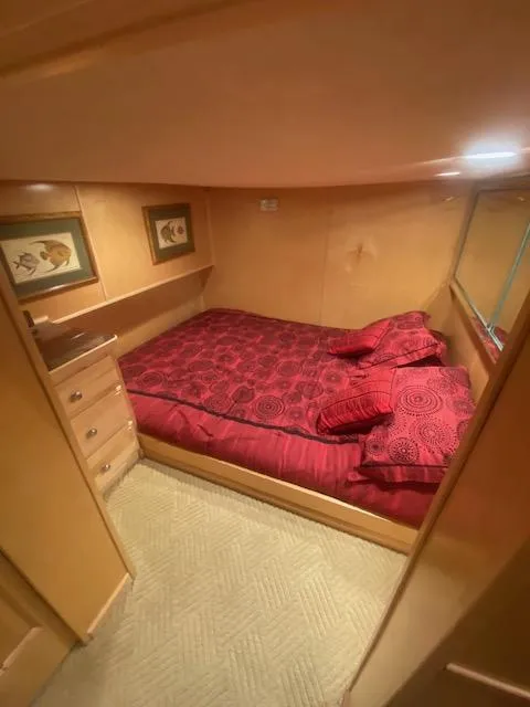 Slide: The Image of Cozy bedroom in 2000 Sumerset 18x85 houseboat with red bedding and wooden cabinetry. - 16