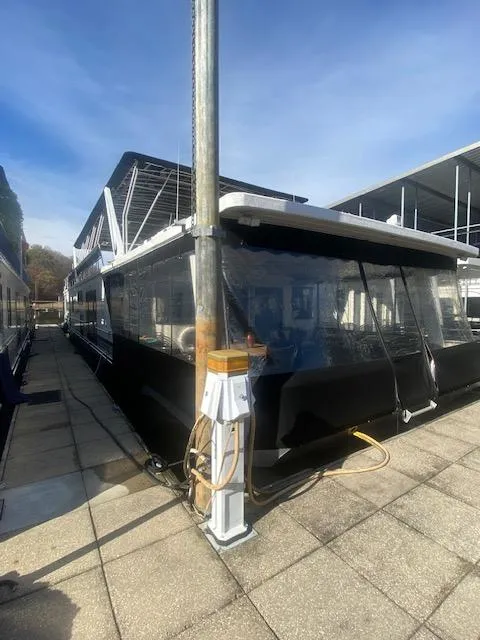 Slide: The Image of 2000 Sumerset 18x85 houseboat docked with covered deck and utility connections. - 2